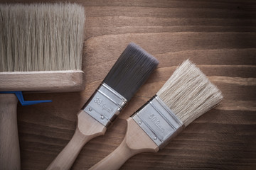 Composition of paint brushes on vintage wood board construction 