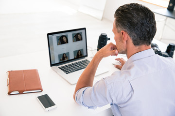 Fototapeta na wymiar Back view portrait of a young man using laptop