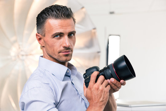 Handsome photographer holding camera
