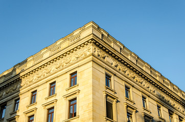 Gelbe Jugendstilfassade vor blauem Himmel