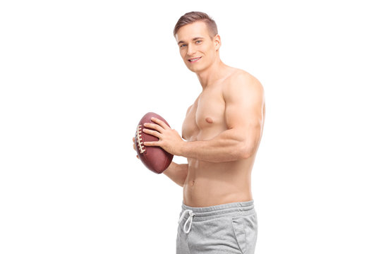 Shirtless young guy holding a football