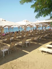 Sunbeds on the beach in a perfect rows