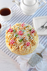 Butter cake with cherries on stand and table setting, on light background