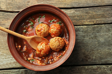 Meat balls with tomato sauce, on wooden background