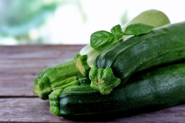 Fresh zucchini with squash and basil on wooden table close up