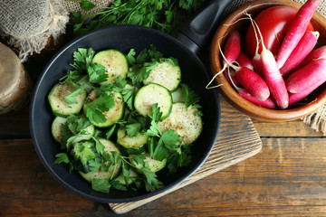 Sliced zucchini in pan on table, top view