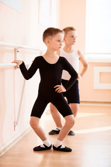 Fototapeta premium Young boys working at the barre in a ballet dance class.