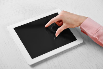 Woman using digital tablet on table close up