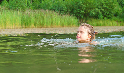 Ten year-old girl swimming in pond
