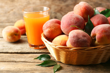 Ripe peaches and juice on wooden background
