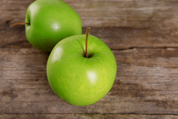 Ripe green apples on wooden table close up