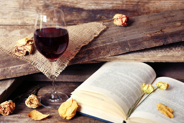 Beautiful composition with glass of wine with old book on table close up