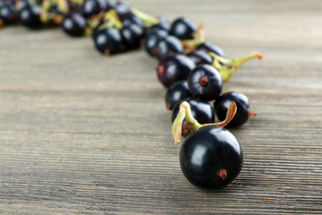 Pile of black currants on wooden table, closeup
