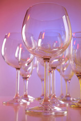Empty wine glasses on color background
