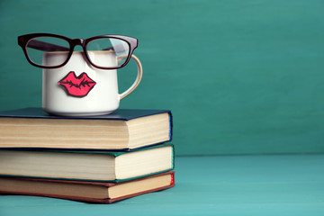 Vintage books and cup with lips on colorful background