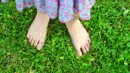 Funny girl's feet on the green grass