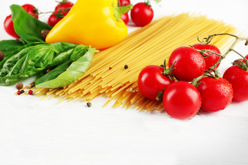 Pasta spaghetti with tomatoes, cheese and basil on color wooden  background