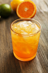 Glass of orange juice on wooden background
