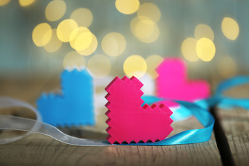 Hearts on wooden table and blurred background with lights