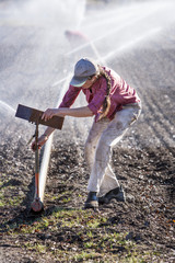 Woman setting irragation sprinklers.