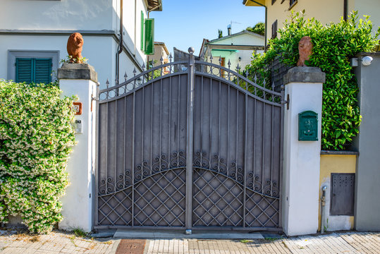 Cancello di ferro grigio, mura, ingresso a casa e villa