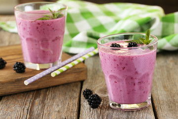 Blackberry smoothie in the glasses on grey wooden background
