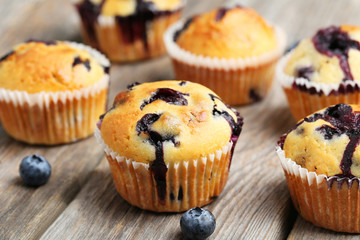 Tasty blueberry muffins on a grey wooden background
