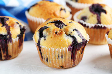 Tasty blueberry muffins on a white wooden background