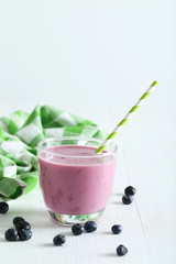 Fresh blueberry smoothie in the glasses on white wooden backgrou