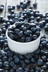 Blueberries in bowl on a blue wooden background