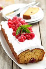 Raspberry cake on plate on grey wooden background