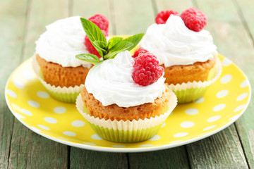 Raspberry cupcakes on green wooden background