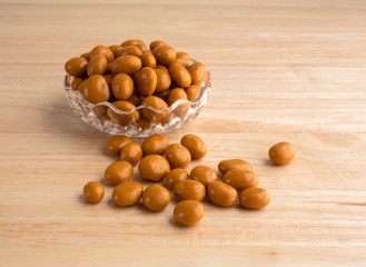 Caramel coated raisins in bowl and on table