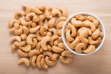 A white bowl with cashew nuts