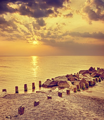 Fototapety  Retro toned dramatic sunset over beach in Dziwnowek, Poland.