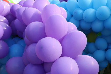 Bunch of purple baloons with blue in background