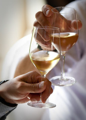 brindisi con calici di vino bianco