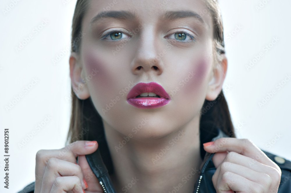 Wall mural Fashion girl with pink lips posing in black leather jacket