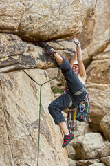 Rock climber clinging to a cliff.