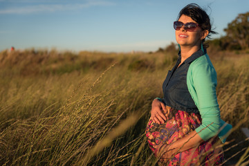 Outdoor shot of young pregnant woman in colorful dress