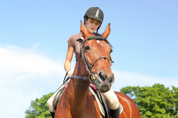 Obraz premium Teenage girl equestrian riding horseback. Vibrant summertime out