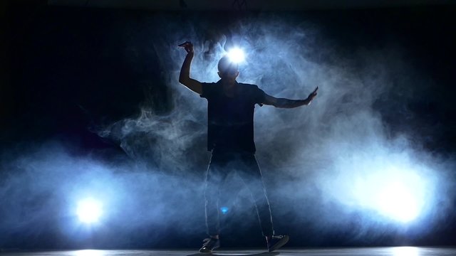 One hip hop break-dancer stylish man dancing, smoke, silhouette