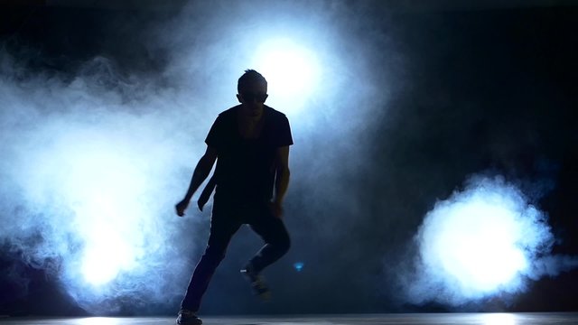 Young hiphop dancer making a move, jump, smoke, silhouette, slow