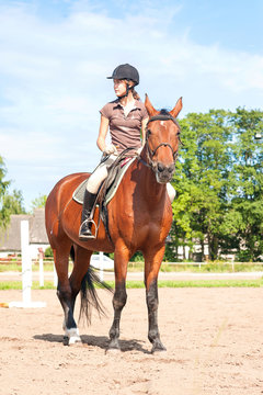 Teenage girl equestrian riding thoroughbred horseback. Vibrant s