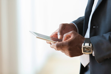 African american business man using a tactile tablet over white