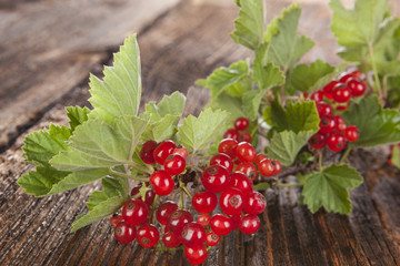 Red currant on wooden background.
