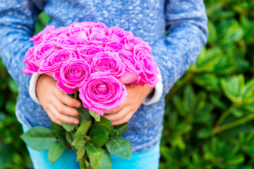 Beautiful bright pink roses in child's hands