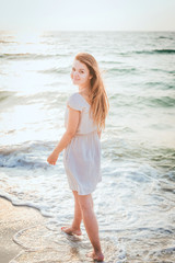 Fototapeta na wymiar young beautiful caucasian female enjoying the sun on beach during sunrise or sunset