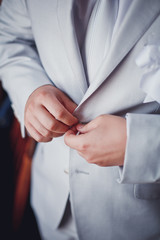 Hands of wedding groom getting ready in suit