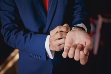 Hands of wedding groom getting ready in suit